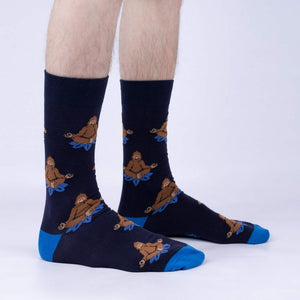 A pair of blue socks with a pattern of cartoon Bigfoot meditating on a lotus flower.