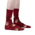 Lifestyle photo showing the Yule Log socks on a person's feet against a light gray background.