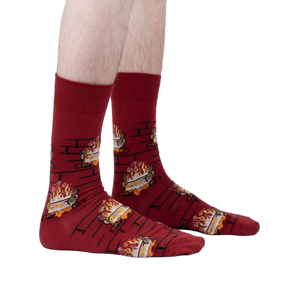 Lifestyle photo showing the Yule Log socks on a person's feet against a light gray background.