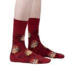 Lifestyle photo showing the Yule Log socks on a person's feet against a light gray background.