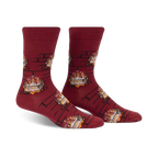 Pair of burgundy crew socks with a repeating pattern of burning yule logs in a fireplace. 
