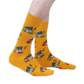 Lifestyle shot of model wearing mustard yellow crew socks featuring cars carrying Christmas trees.