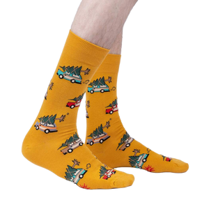 Lifestyle shot of model wearing mustard yellow crew socks featuring cars carrying Christmas trees.