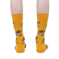 Rear view of mustard yellow crew socks with Christmas tree-hauling car pattern.