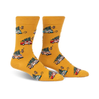 Pair of mustard yellow crew socks with a repeating pattern of cartoon cars carrying Christmas trees. 