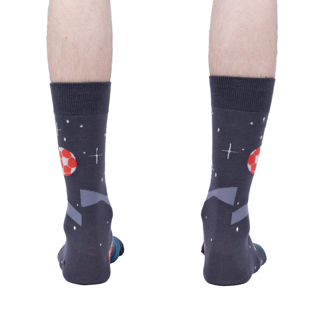 Rear view of 'Lets Kick It' socks worn on a person's feet showing the complete back of the sock design.