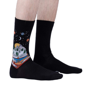 Lifestyle shot of a person's legs wearing the black 'Take a Look It's in a Book' socks, showcasing the design and fit.