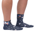 Lifestyle shot of a person wearing the Sitting Kitty Turn Cuff socks, standing against a white background.