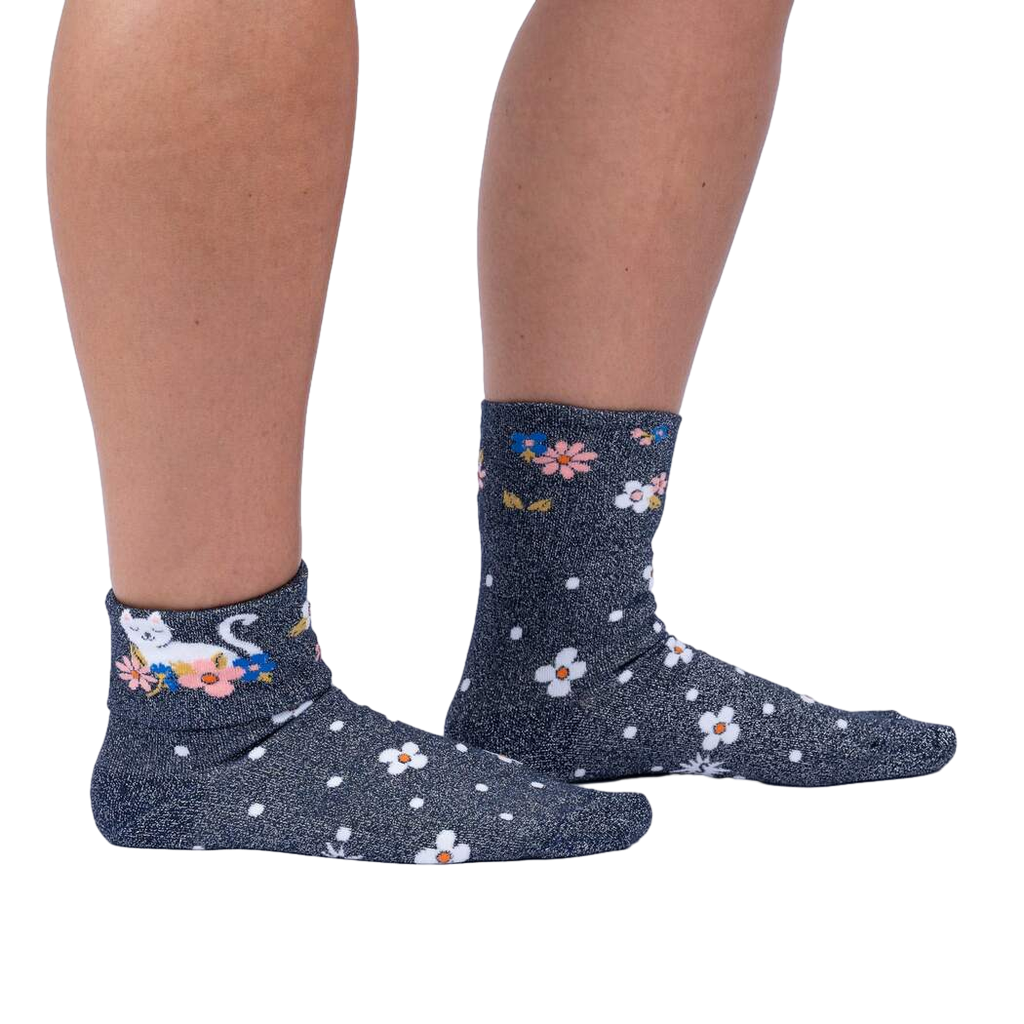 Lifestyle shot of a person wearing the Sitting Kitty Turn Cuff socks, standing against a white background.