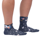 Lifestyle shot of a person wearing the Sitting Kitty Turn Cuff socks, standing against a white background.