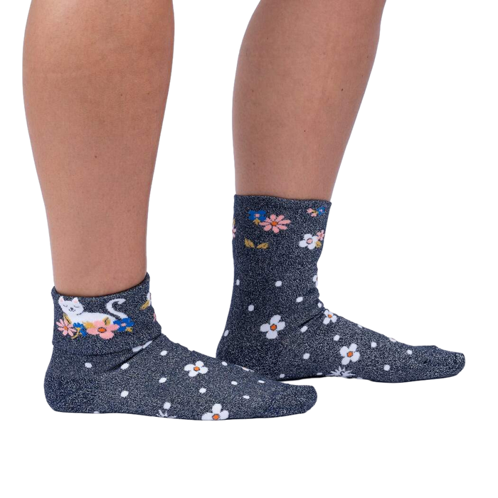 Lifestyle shot of a person wearing the Sitting Kitty Turn Cuff socks, standing against a white background.