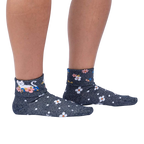 Another lifestyle shot of a person wearing the Sitting Kitty Turn Cuff socks, standing against a white background, from a slightly different angle.
