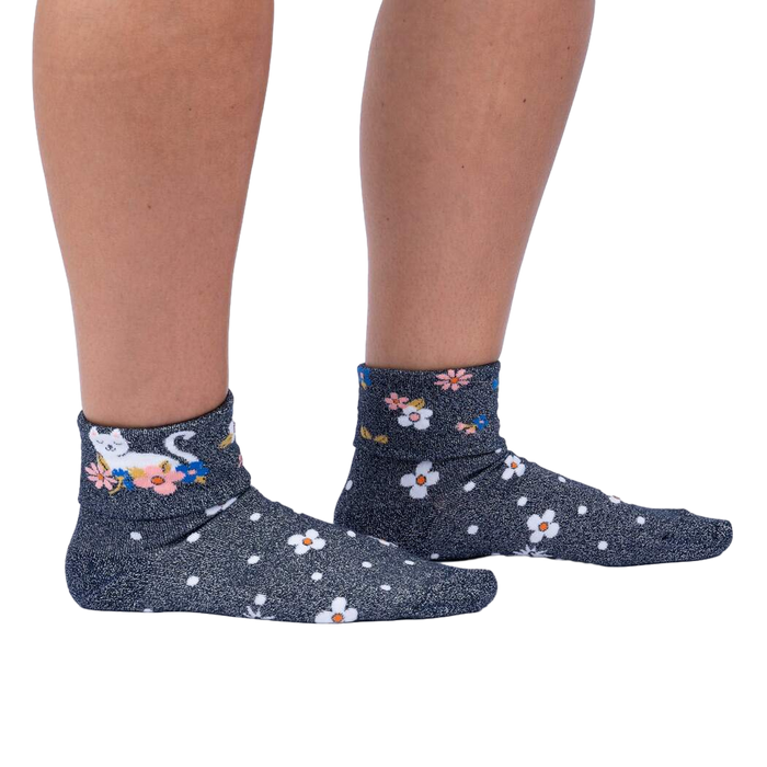 Another lifestyle shot of a person wearing the Sitting Kitty Turn Cuff socks, standing against a white background, from a slightly different angle.