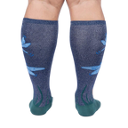 Rear view of model's legs wearing the teal and navy blue knee-high socks with dragonflies.