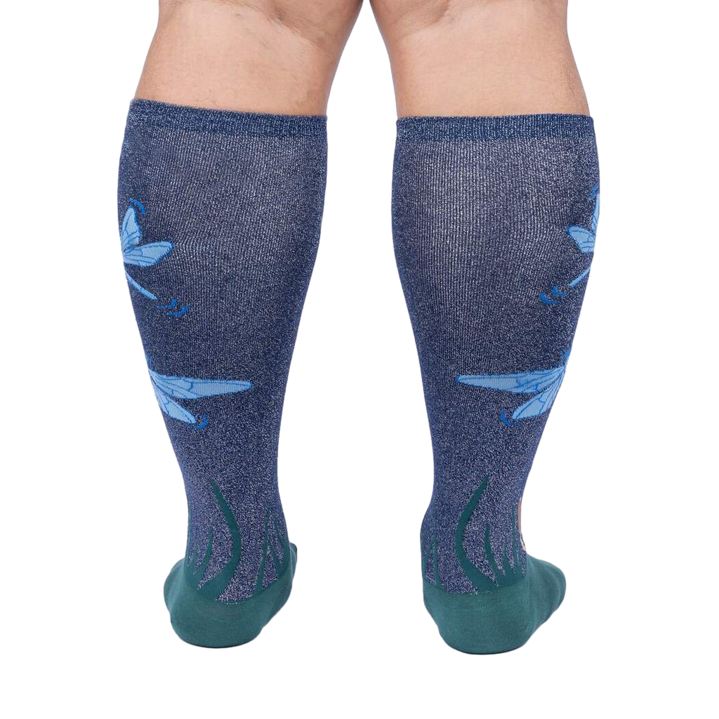 Rear view of model's legs wearing the teal and navy blue knee-high socks with dragonflies.
