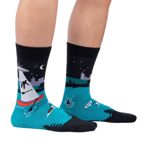 A pair of black socks with a colorful pattern of UFOs and a lake.