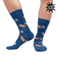 Lifestyle shot of a person wearing the 'Weiner Dogs, In Space!' socks, showcasing the glow-in-the-dark effect.