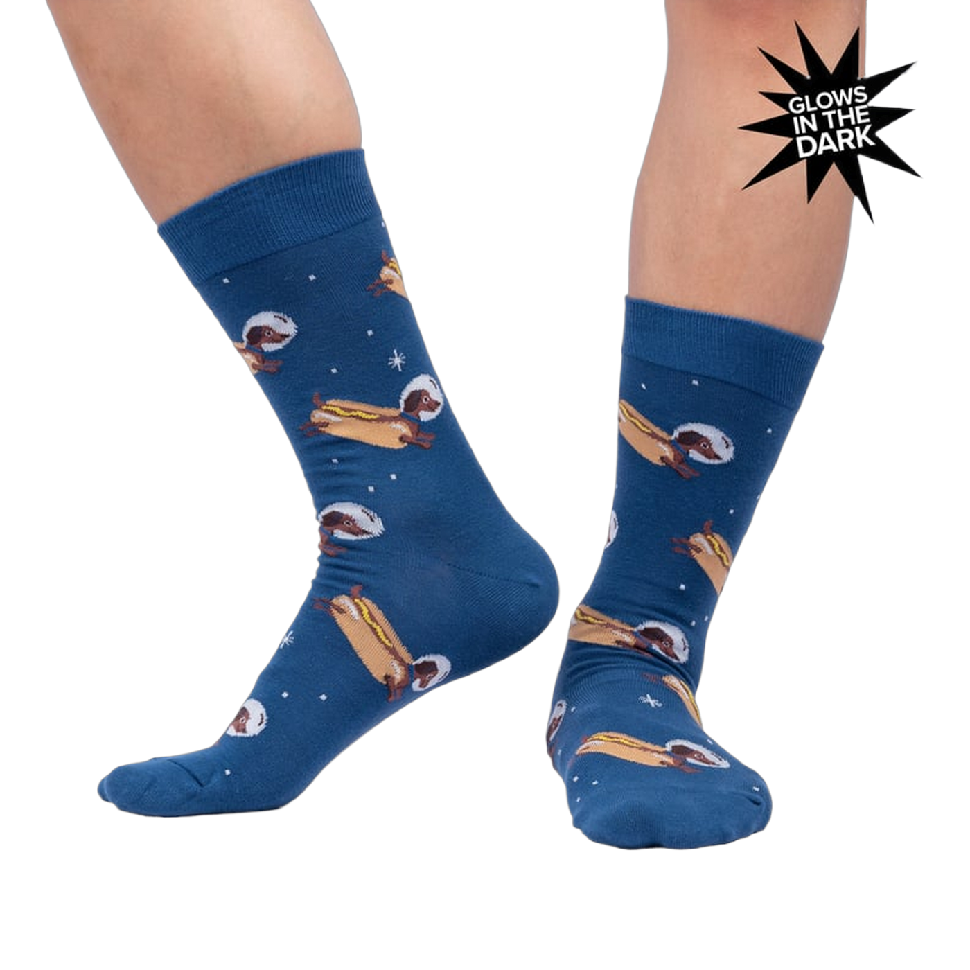 Lifestyle shot of a person wearing the 'Weiner Dogs, In Space!' socks, showcasing the glow-in-the-dark effect.