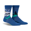Pair of blue crew socks with a graphic design of an RV driving through a mountain landscape.  Features a whimsical sun and green trees.