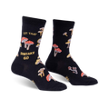 Pair of black crew socks with a whimsical mushroom and 'Let That Shiitake Go' design. Red and gold mushrooms are scattered across the black fabric.
