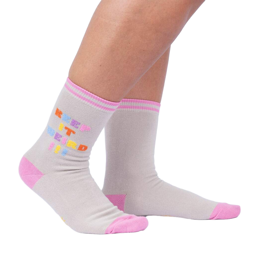 Lifestyle shot showcasing 'Keep It Weird!' socks on a person's legs, highlighting the fit and style.