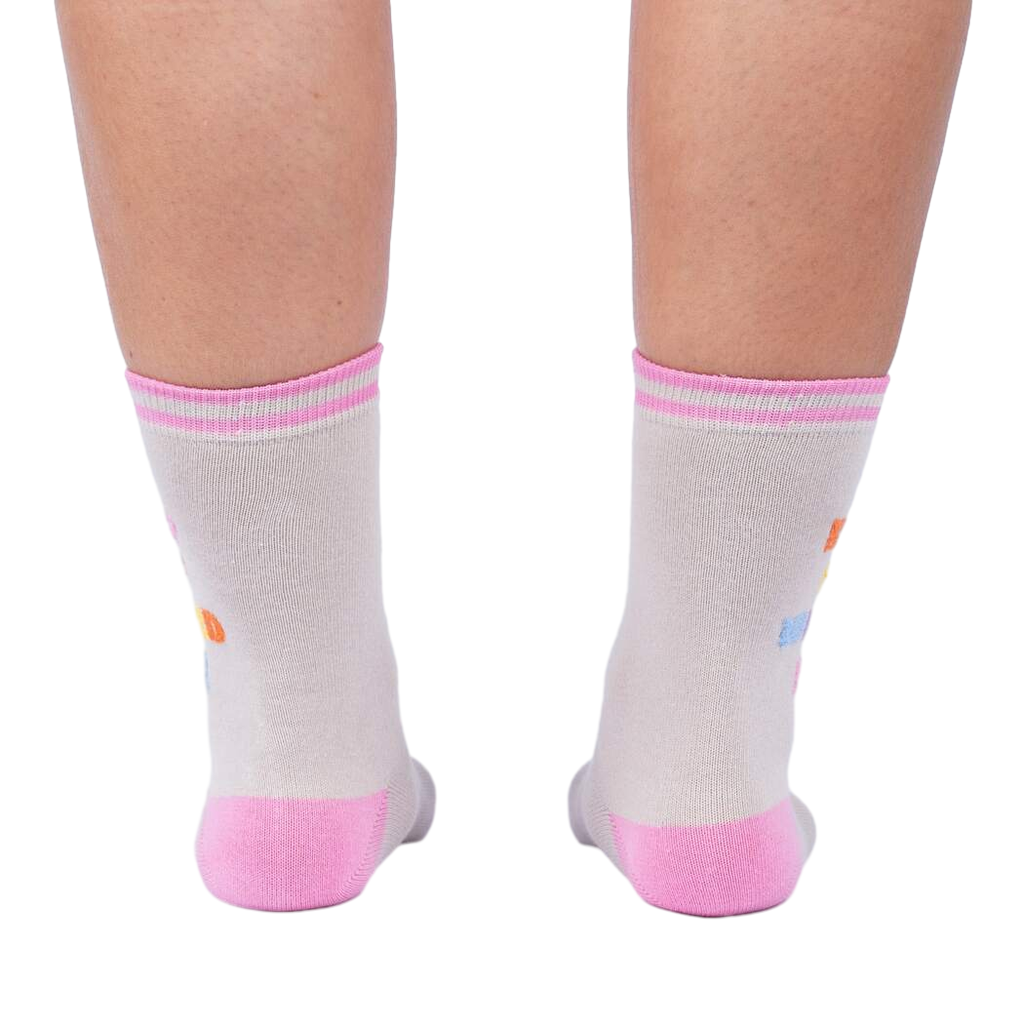 Rear view of 'Keep It Weird!' socks on a person's legs, showing the pink cuffs and subtle sock details.