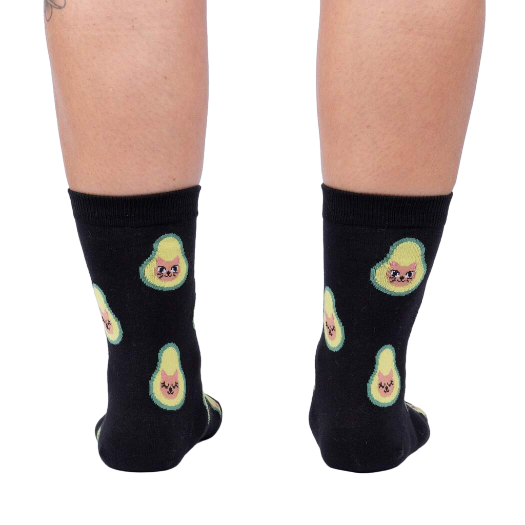 Back view of the same socks shown on a person's legs.  The avocado-cat design is clearly visible from behind.