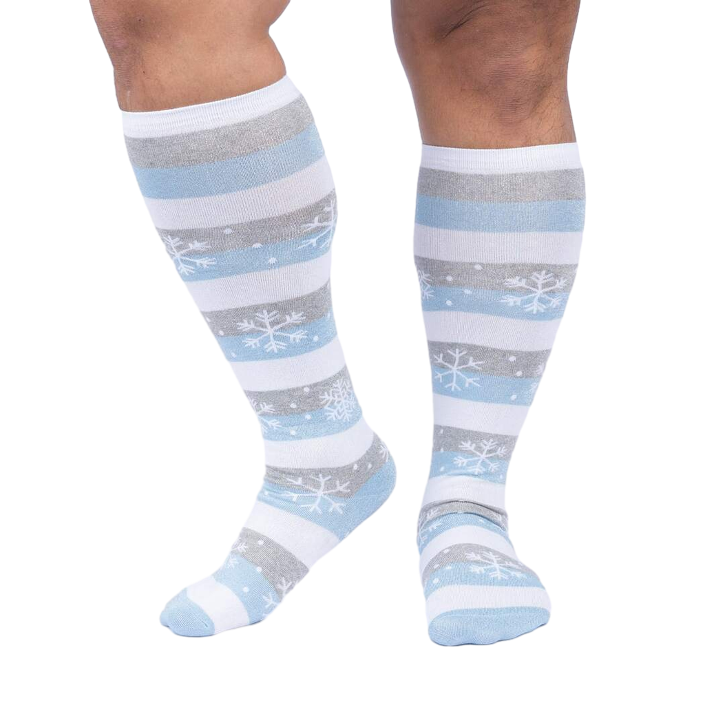 Close-up of a person's legs wearing the snowflake and stripe knee-high socks.