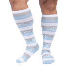 Close-up of a person's legs wearing the snowflake and stripe knee-high socks.
