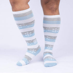 A pair of knee-high socks with a snowflake pattern in light blue and gray on a white background.