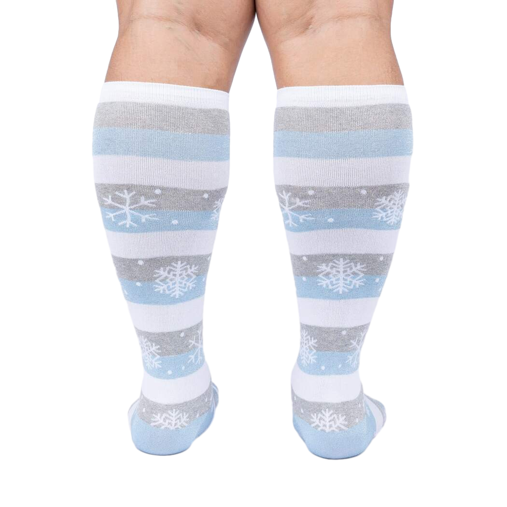 Back view of a person modeling the snowflake and stripe knee-high socks.