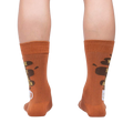 Rear view of the socks on a person's legs, highlighting the back design of the coffee cup and text.