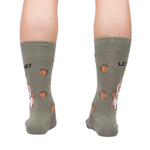 A pair of green socks with a pattern of squirrels holding acorns. The socks have the text 