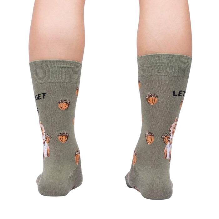 A pair of green socks with a pattern of squirrels holding acorns. The socks have the text 