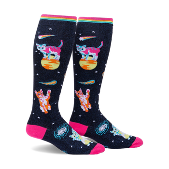 Pair of knee-high socks on a white background. Black background with pink, orange, and teal space cats, stars, and comets. Rainbow top cuff.