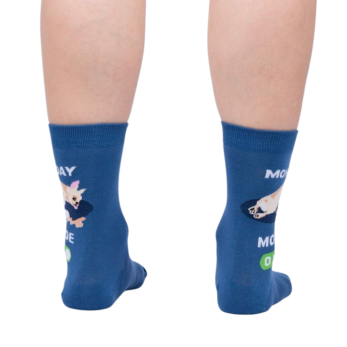 A pair of blue socks with a chihuahua on them. The chihuahua is sleeping on the word 