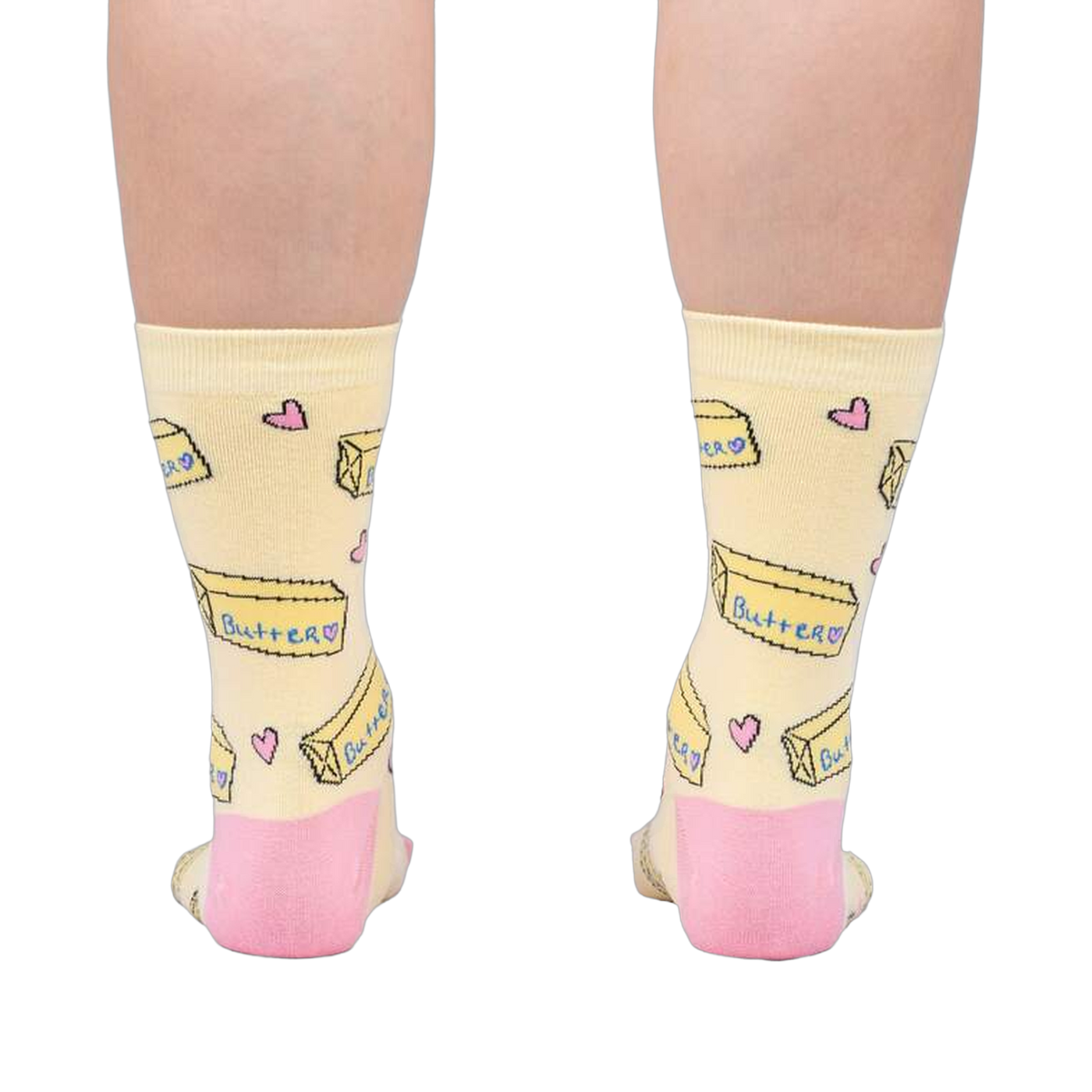 Rear view of the socks on a person's legs, highlighting the pink heel and toe details against the pastel yellow.