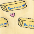 Close-up detail shot of the sock fabric, emphasizing the butter pat and heart design elements.