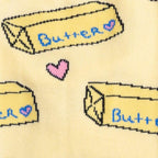 Close-up detail shot of the sock fabric, emphasizing the butter pat and heart design elements.