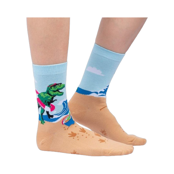 Lifestyle shot of Dinos Gone Wild socks on a person's feet, showcasing the beach-themed design.