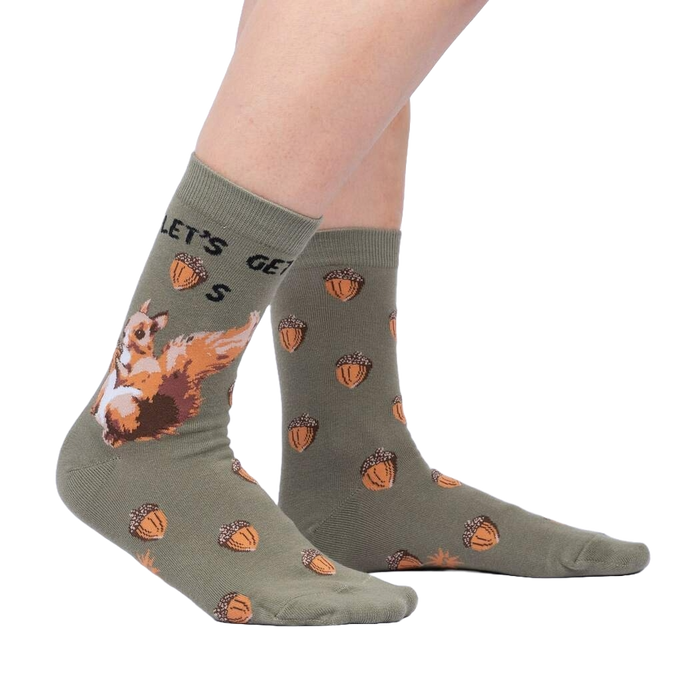 A pair of green socks with a pattern of cartoon squirrels holding acorns.