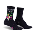 Black crew socks with a whimsical design. Features a carrot, radish, and turnip with faces, along with the text 'Rooting For You!'  Small pink dots are on the socks as well.