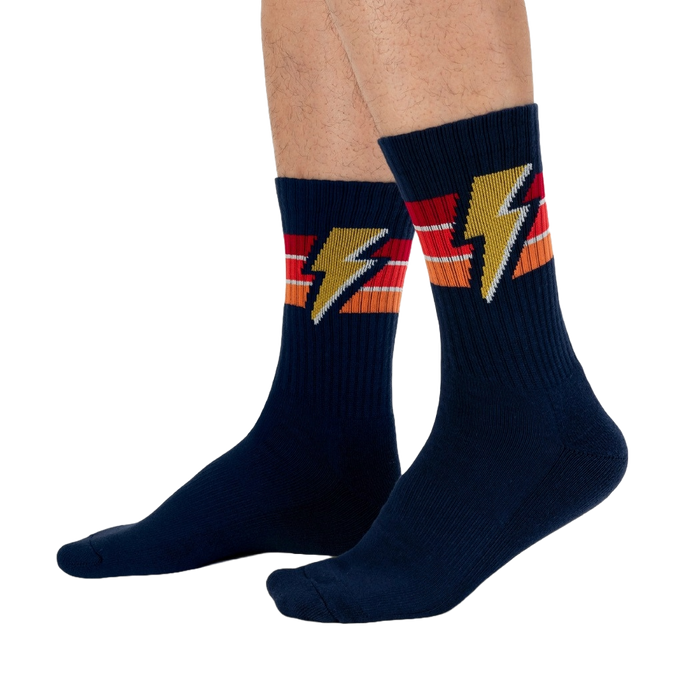 A pair of blue socks with an orange, red, and yellow lightning bolt pattern.