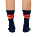 Rear view of navy blue Thunderstruck socks on a person's legs.