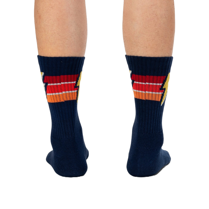 A pair of blue socks with an orange, red, and yellow lightning bolt pattern.