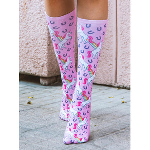 A pair of pink knee-high socks with a pattern of white unicorns with rainbow manes and tails leaping over golden horseshoes.