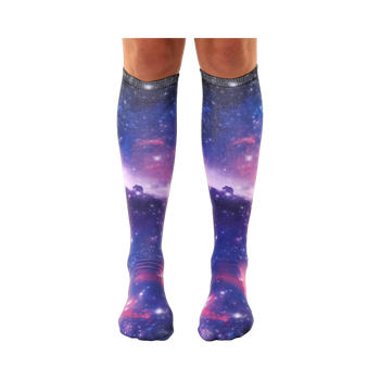 Pair of knee-high socks showcasing a vibrant galaxy print in shades of purple, blue, and pink.  Tiny white stars and nebulae are visible throughout the design.