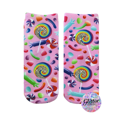 A pair of pink crew socks with a candy design.  Lollipops, gummy candies, and swirl candies are printed on a pink background with glitter accents.