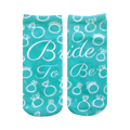 A pair of teal ankle socks with a pattern of white rings and diamonds. Text reads, 'Bride To Be'. Perfect for brides-to-be!