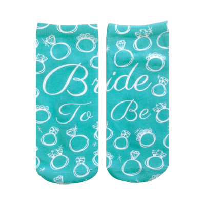 A pair of teal ankle socks with a pattern of white rings and diamonds. Text reads, 'Bride To Be'. Perfect for brides-to-be!